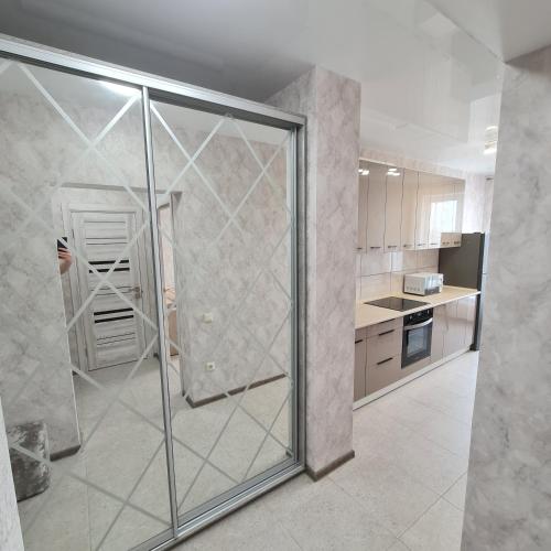 a kitchen with a glass shower in a room at Апартаменты in Odesa