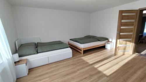 a white room with a couch and a bed at Apartmán Kozolupy in Kozolupy