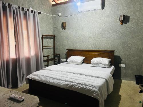 a bedroom with a bed with white sheets and white pillows at SRI Villa in Busse
