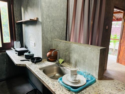 a kitchen counter with a sink with a plate on it at SRI Villa in Busse