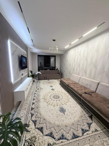 a living room with a couch and a flat screen tv at Frunze Residence in Osh