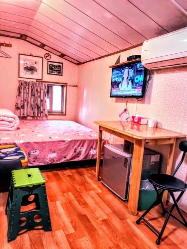 a bedroom with a bed and a table and a television at Yun Cheng Homestay in Jiufen
