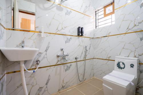 a bathroom with a sink and a toilet at Odilia Apartelle in Bangalore