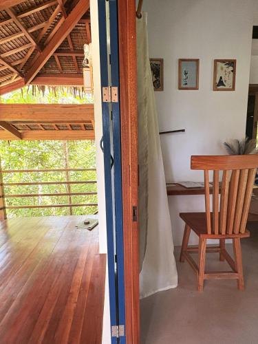 a room with a wooden chair and a table at Confluence Siargao in General Luna