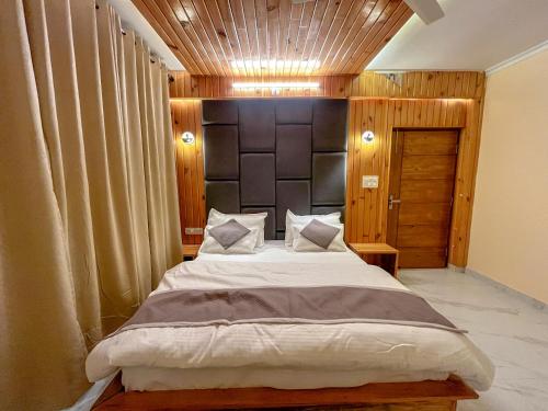 a bedroom with a large bed in a room at Mount kirola stay in Bhowāli