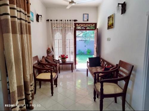a living room with chairs and a table and a window at Sithula Villa in Bentota