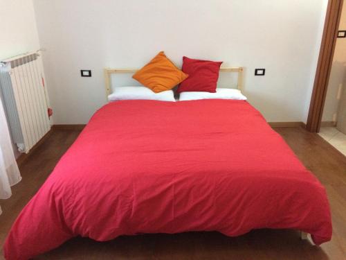 - une grande couverture rouge sur un lit dans l'établissement Casaretto Apartment near Hospital Gaslini Genova, à Gênes