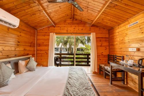 a bedroom with a large bed in a wooden room at Beach Walk Resort Walk In Morjim Beach Goa in Morjim