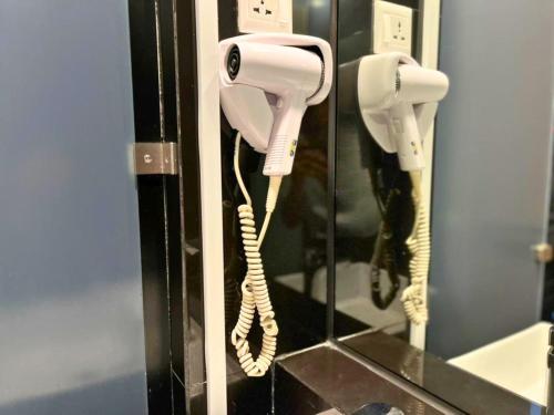 a white phone is hanging on a wall at Seeds Hotel Premier One City Subang Previously eCity Hotel One City in Subang Jaya