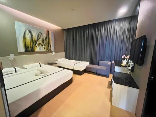 a living room with a couch and a tv in it at Seeds Hotel Premier One City Subang Previously eCity Hotel One City in Subang Jaya