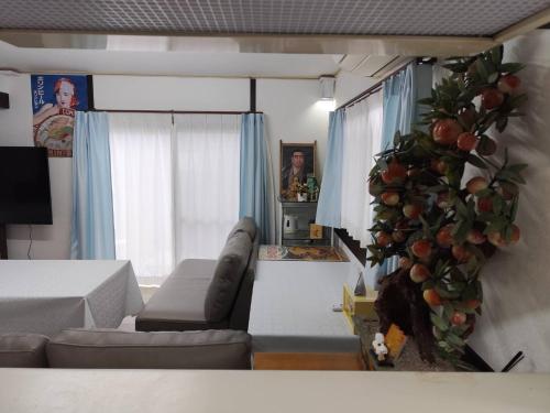 a living room with a couch and an orange tree at 夢尽くし in Aira