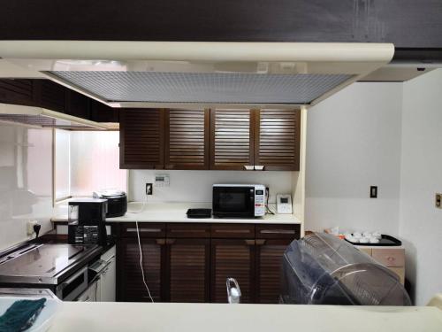 a kitchen with wooden cabinets and a microwave at 夢尽くし in Aira