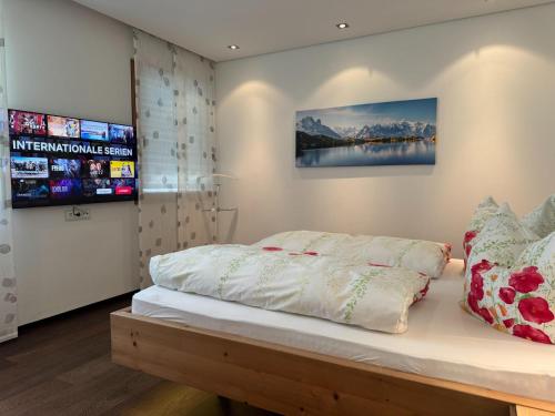a bedroom with a bed and a tv on the wall at Villa in Tyrol with pool in Stanz bei Landeck