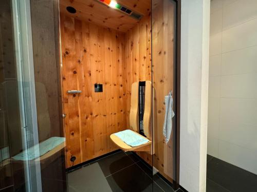 a bathroom with a wooden wall with a phone in it at Villa in Tyrol with pool in Stanz bei Landeck