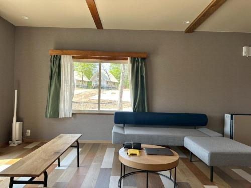 a living room with a blue couch and a table at Asahi Shizenkan in Asahi-machi