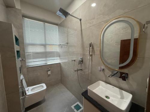 a bathroom with a sink toilet and a mirror at The Hotel Art 8 in Pātan