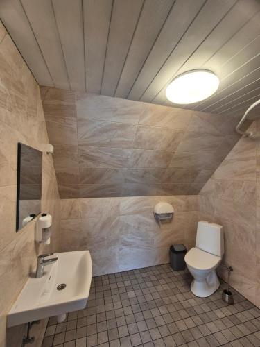a bathroom with a white toilet and a sink at Risti kodumajutus in Lemsi
