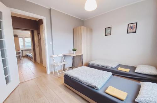 a room with two beds and a desk in it at Dobre Sny na Konopnej in Bydgoszcz