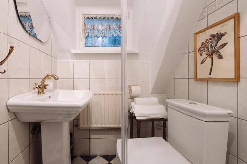 a white bathroom with a sink and a toilet at Willa Pałacyk in Świeradów-Zdrój