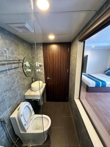 a bathroom with a toilet and a sink and a bed at Calla Lily Hotel in Sapa