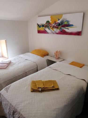 two beds with a tray on top of them in a room at La Clef in Saint-Julien-Molin-Molette
