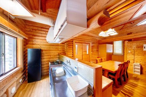 a kitchen and dining room in a log cabin at Kyukamura Taishakukyo in Shōbara