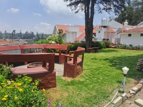 a park bench sitting in the grass in a yard at Milestone Heritage Inn in Jāmb