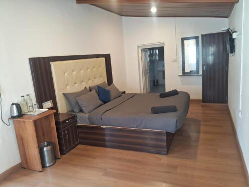 a bedroom with a large bed and a wooden floor at Milestone Heritage Inn in Jāmb