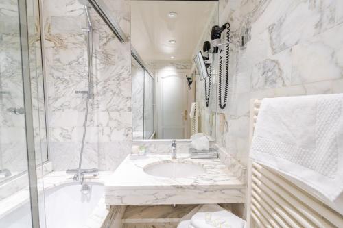 un bagno con lavandino e doccia di Hotel d'Angleterre a Chalons en Champagne