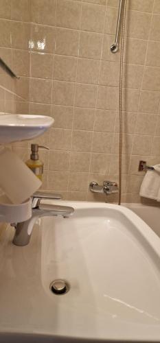 a bathroom with a white tub and a sink at Pension Maria in Antdorf