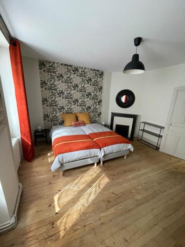 a bedroom with a bed and a wooden floor at Le gîte de Marie in Gramat