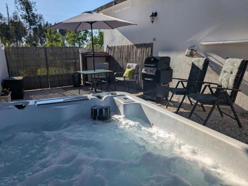 a plunge pool with a table and an umbrella at CASA CURRAL do Porco in Tábua
