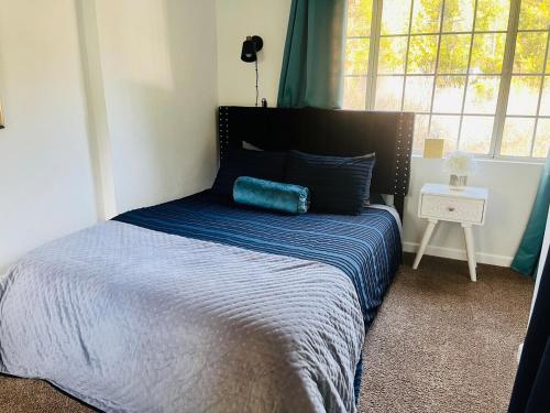 a bedroom with a bed with a blue blanket and a window at Dafna, Unit 4 in Cromberg