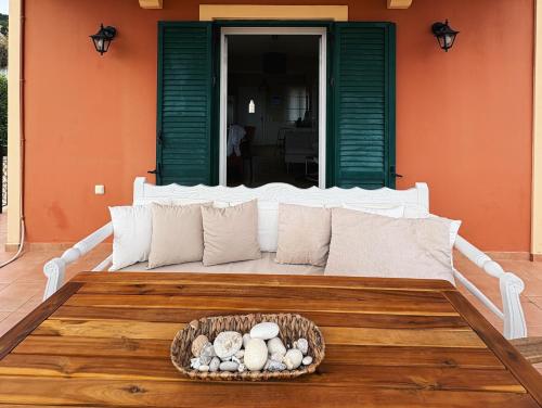 a white bed with a bowl of rocks on a table at Sea View Villa Irene - Private Pool and Sunset Terrace in Evretí