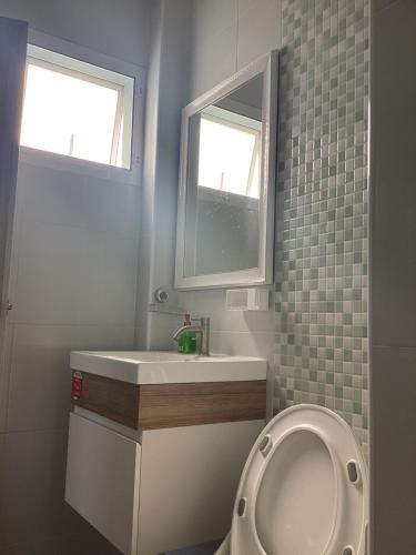 a bathroom with a toilet and a sink and a window at Naris Riverside in Ban Wat Tha Maprang