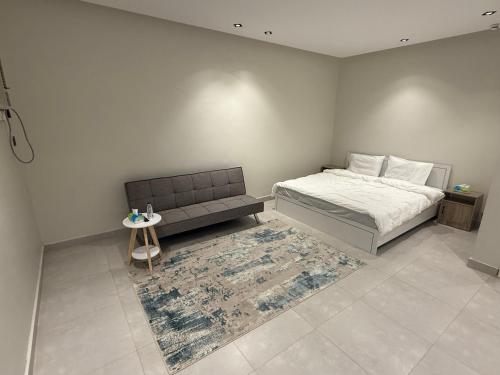 a bedroom with a bed and a couch and a rug at comfortable hotel in Jeddah