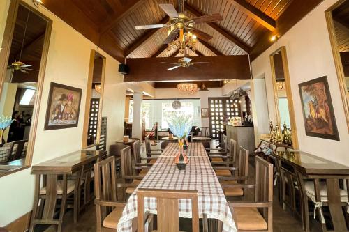 a restaurant with a long table with chairs and a ceiling at Windy Ridge Hotel Tagaytay in Tagaytay