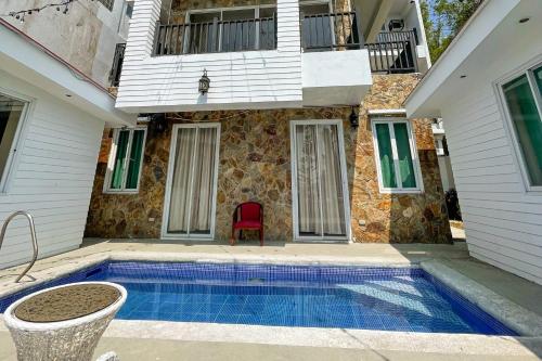 a house with a swimming pool in front of a house at Windy Ridge Hotel Tagaytay in Tagaytay