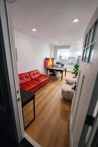 a living room with a red couch and a table at Vernon Stay Near BMO Stadium in Los Angeles