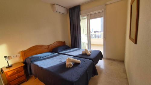 a bedroom with two beds with towels on them at Gemelos 22-Fincas Benidorm in Benidorm