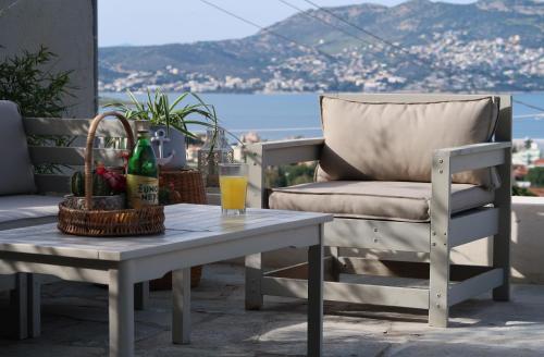 a chair and a table with a drink on a patio at Hippie Bay Complex in Porto Rafti