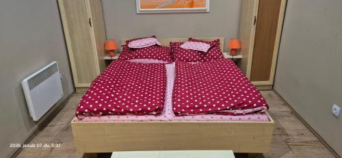 a bed with polka dot sheets and pillows on it at Levente vendégház in Szilvásvárad