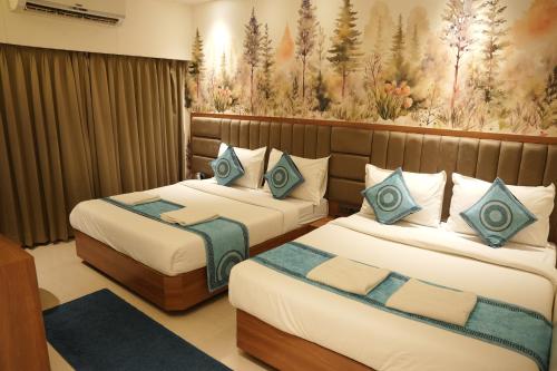 a hotel room with two beds and a painting on the wall at Hotel Sai Seeta Palace Newly Renovated in Shirdi
