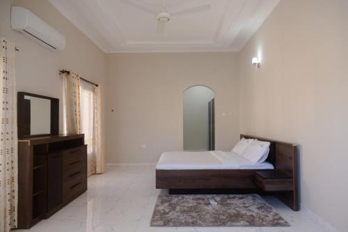 a bedroom with a bed and a dresser and a mirror at Tanga New Apartments in Tanga