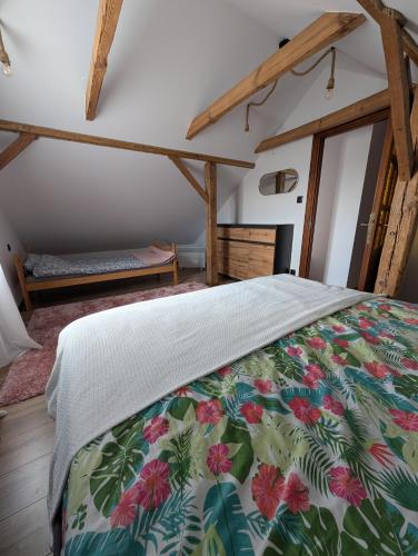 a bedroom with a bed with a floral bedspread at Agroturystyka WROTA PODLASIA in Siemiatycze