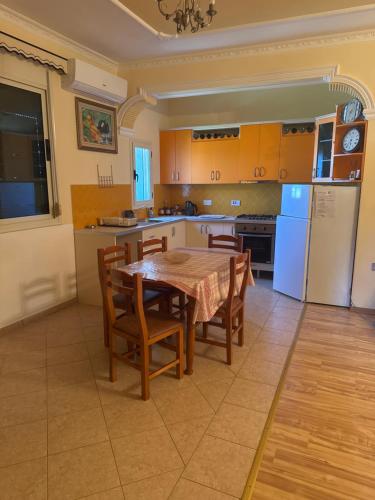 a kitchen with a table and chairs and a refrigerator at Villa 24 maj cole vlore in Vlorë