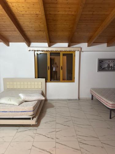 a bedroom with two beds and a wooden ceiling at Villa 24 maj cole vlore in Vlorë
