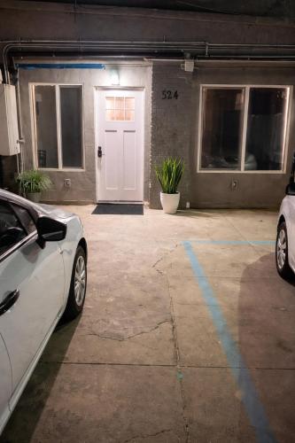 two cars parked in a garage with a white door at Vernon Stay Near BMO Stadium in Los Angeles