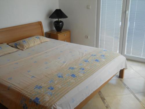a bedroom with a bed with blue flowers on it at Apartments Ognjenović in Risan