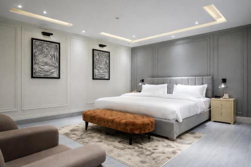 a bedroom with a large white bed and a chair at Scenic Hotel Near Earthquake Memorial Bridge,203 in Muzaffarabad